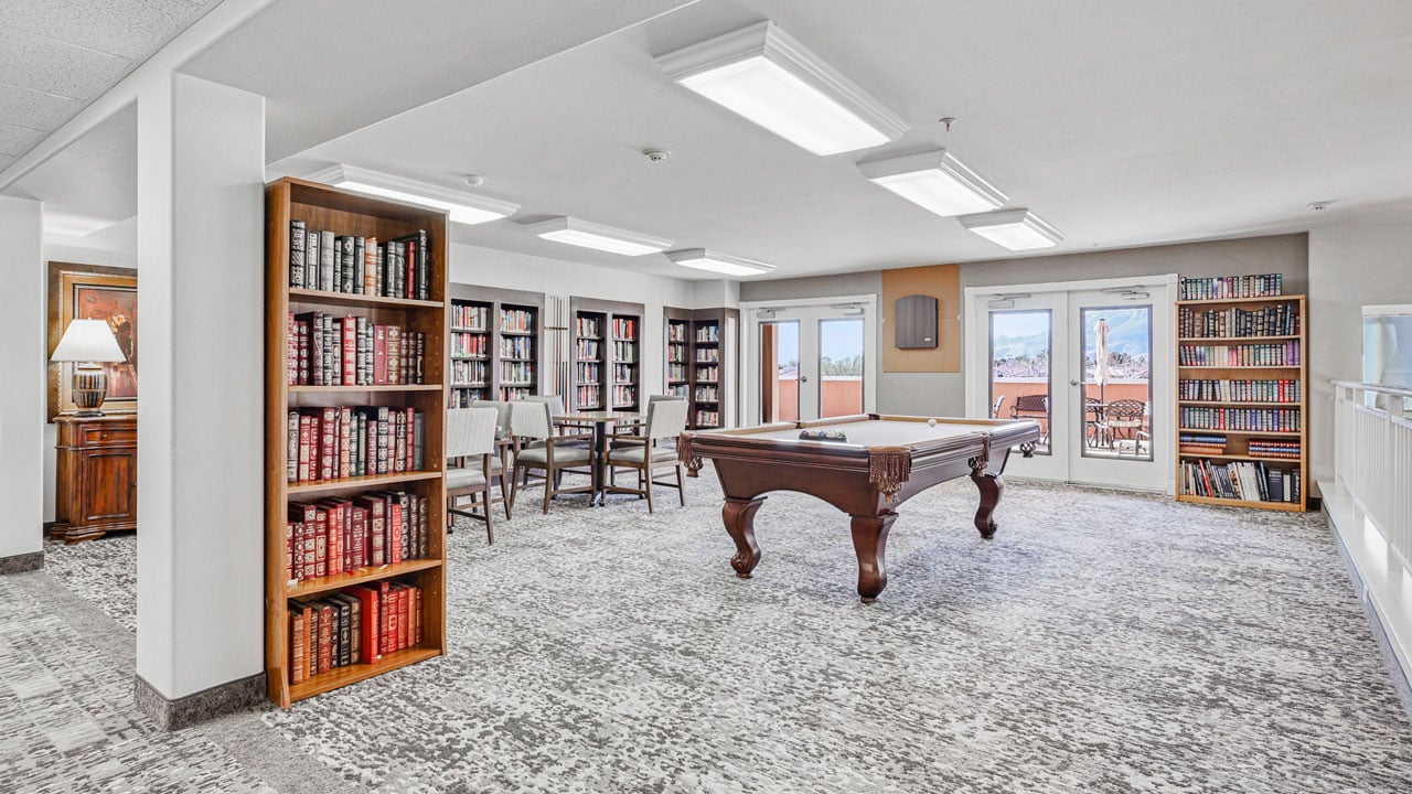 The library at Mountain View Gardens with shelves of books and comfortable seating