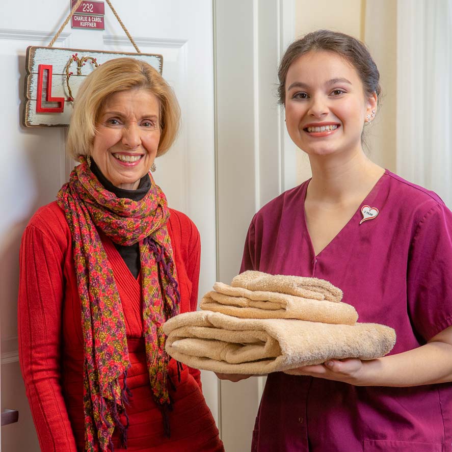 A team member delivering fresh linens to a resident at Mountain View Gardens